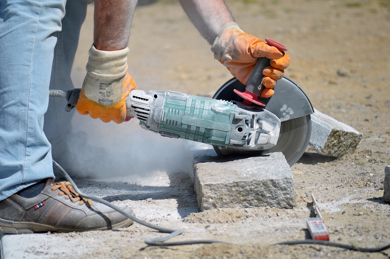 Operatore utilizza una smerigliatrice angolare con dispositivi di protezione per lavorazioni in sicurezza