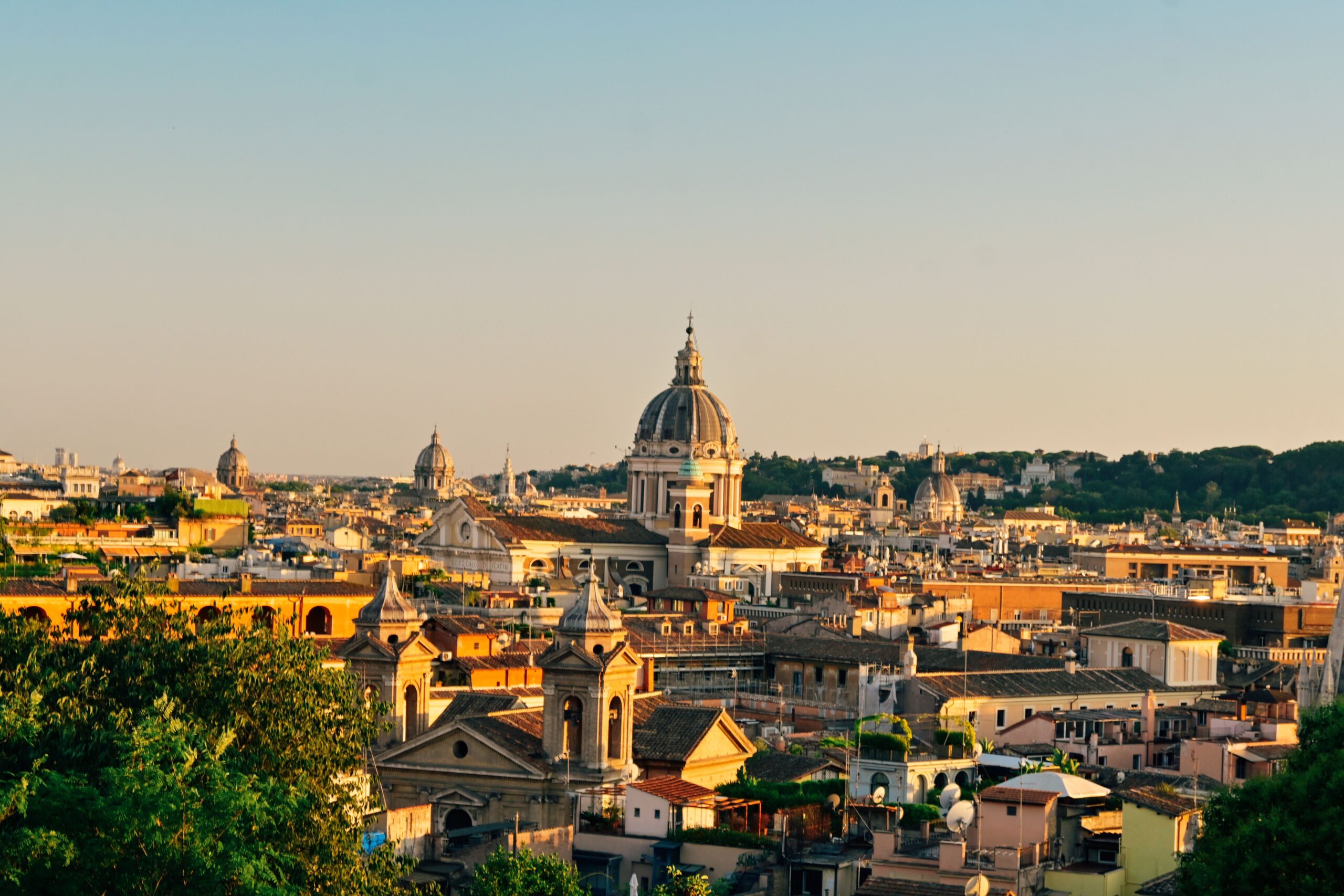 Capture the timeless beauty of Rome's skyline at sunset with its iconic domes and ancient buildings.