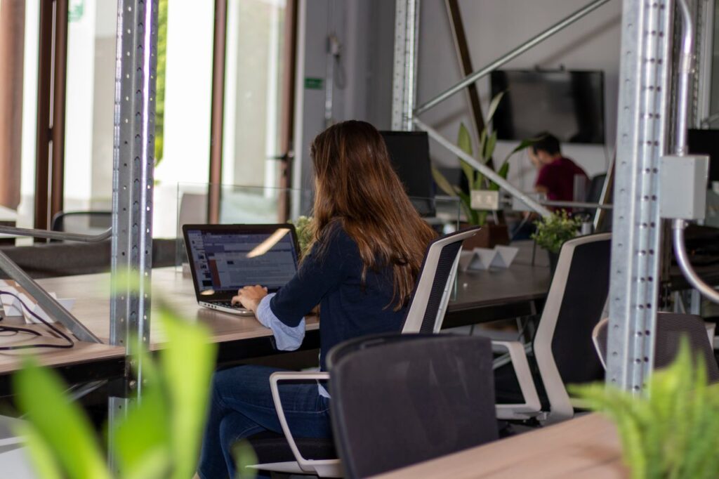 Woman working on a laptop in a stylish coworking office space.